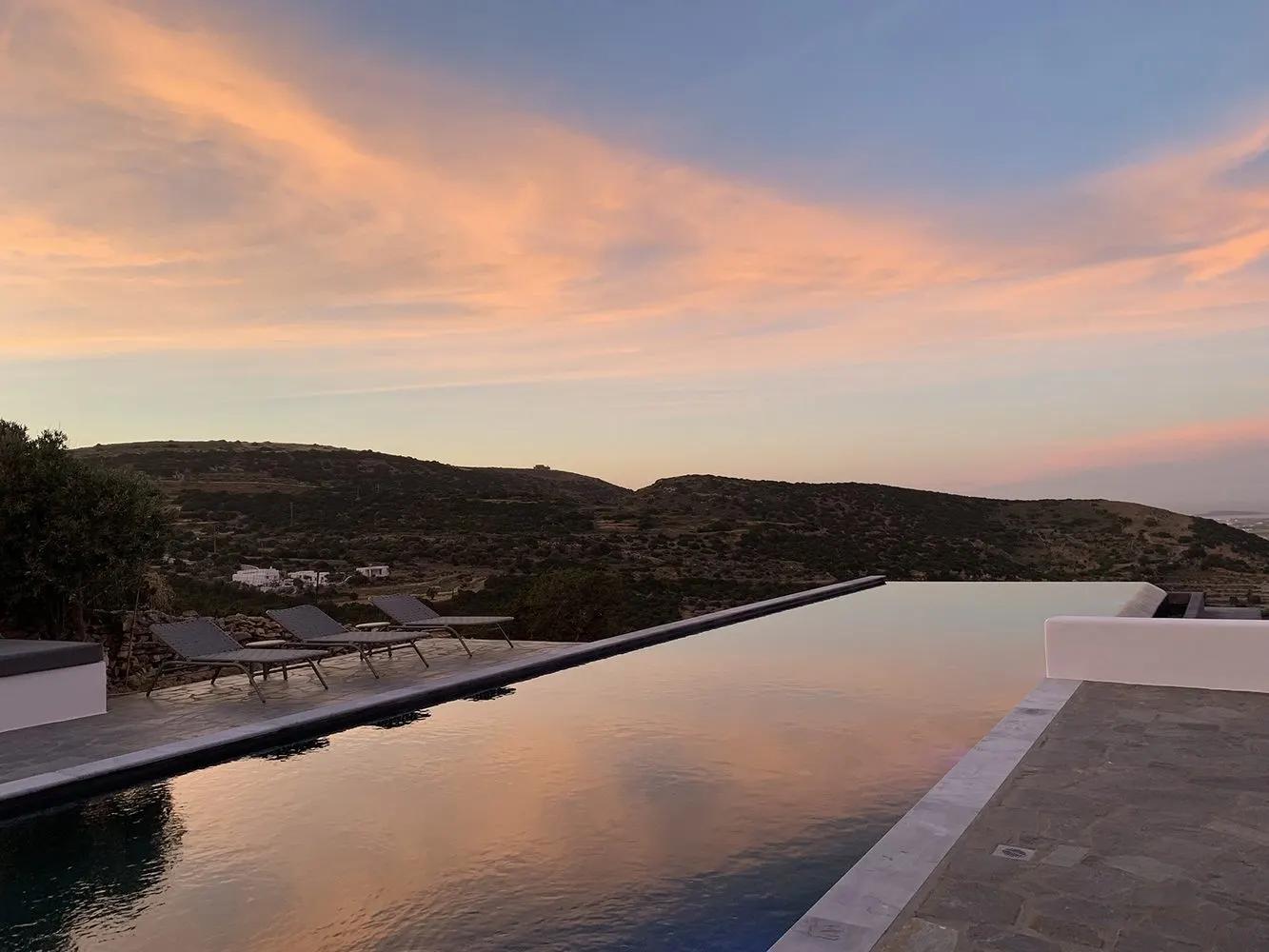 The infinity pool at dusk under a rose-coloured sky